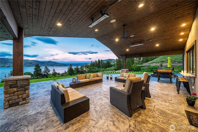 patio terrace at dusk featuring a water view and an outdoor hangout area