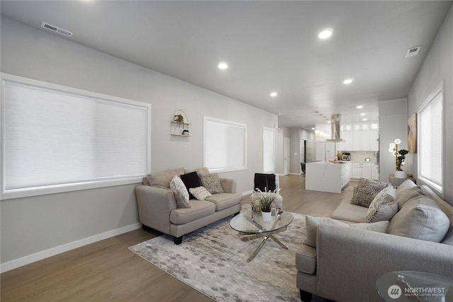 living room with recessed lighting, visible vents, and light wood-style floors