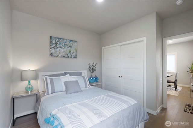 bedroom with a closet, baseboards, and wood finished floors