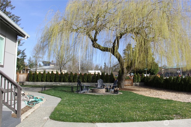 view of yard featuring a fenced backyard and a fire pit