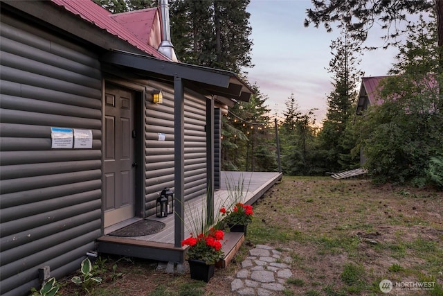 property exterior at dusk with log veneer siding and metal roof