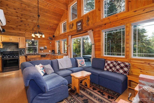 living area with wooden ceiling, a healthy amount of sunlight, wooden walls, and light wood finished floors