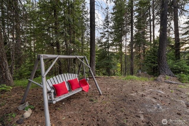 view of jungle gym featuring a forest view