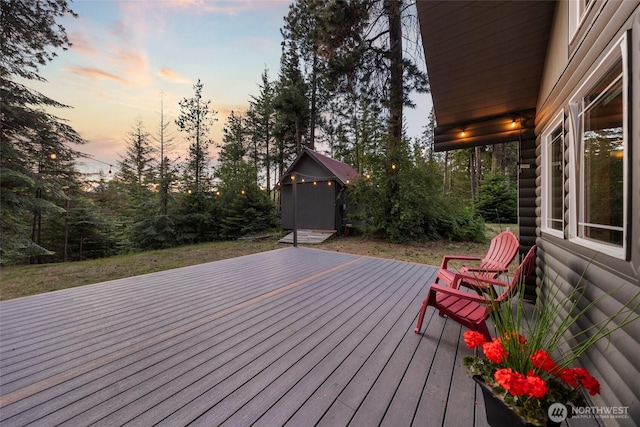 wooden deck with a storage unit and an outdoor structure