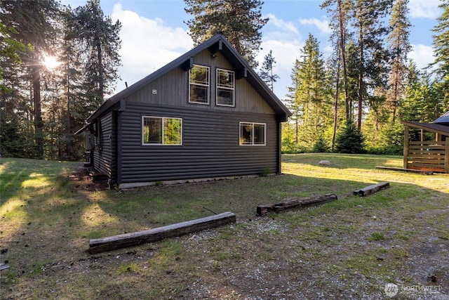 view of side of home featuring a yard and log veneer siding