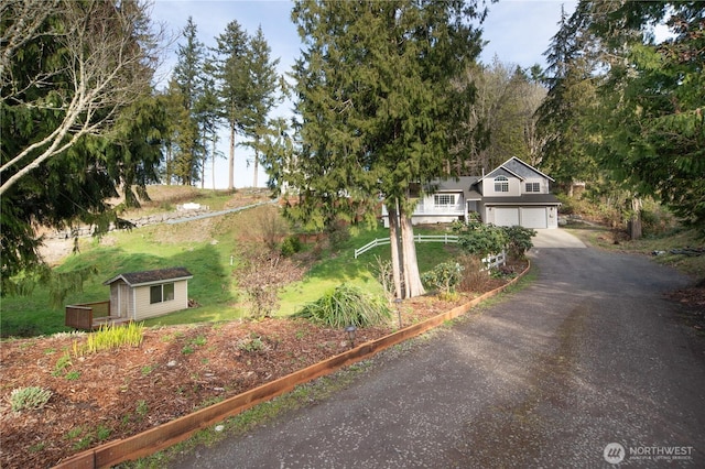 view of front of house featuring driveway, a shed, and an outdoor structure