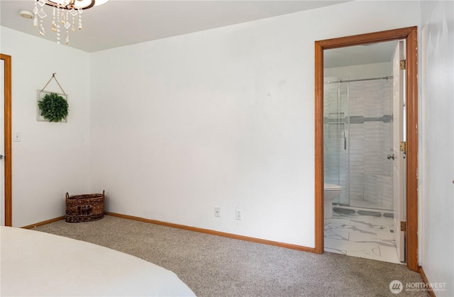 carpeted bedroom featuring a chandelier, connected bathroom, and baseboards