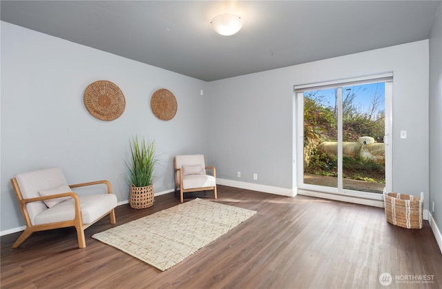 living area with baseboards and wood finished floors