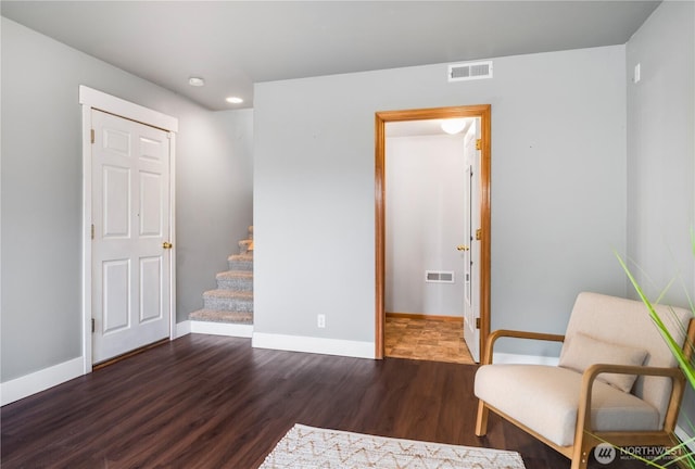 sitting room with baseboards, visible vents, and wood finished floors