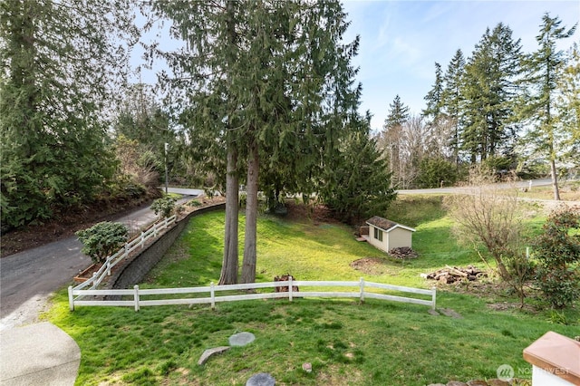 view of yard featuring fence and an outbuilding