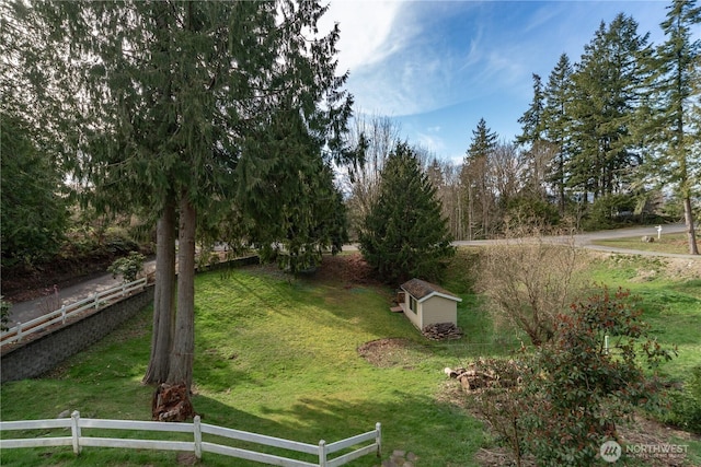 view of yard with fence and an outdoor structure