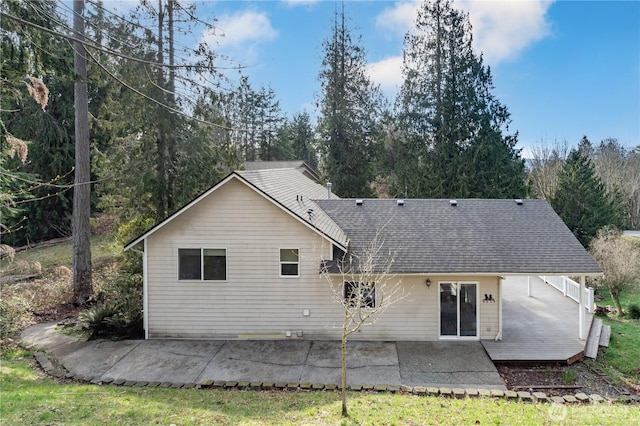 back of house with a patio area and roof with shingles