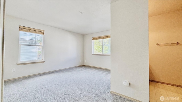 carpeted spare room with baseboards