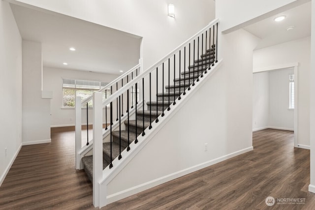 stairs featuring baseboards, wood finished floors, and recessed lighting