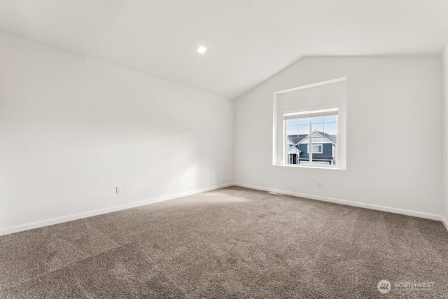 unfurnished room with visible vents, baseboards, vaulted ceiling, and carpet flooring