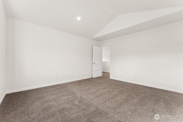 carpeted empty room with vaulted ceiling and baseboards