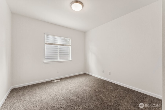 empty room featuring carpet, visible vents, and baseboards