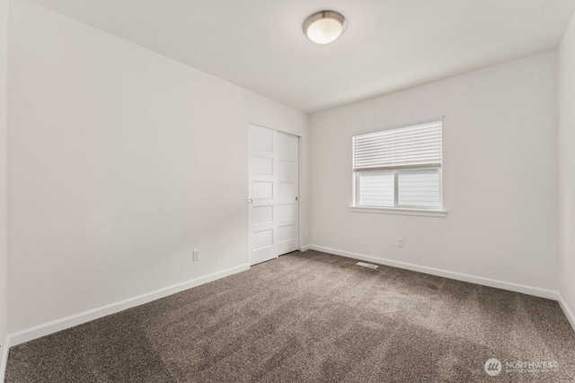 spare room with carpet and baseboards