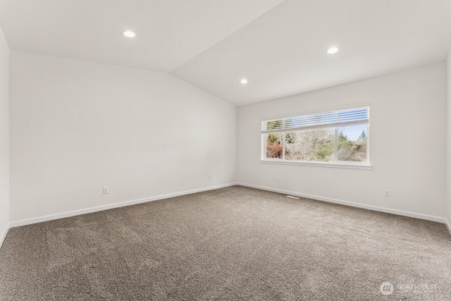 empty room with lofted ceiling, baseboards, and carpet flooring