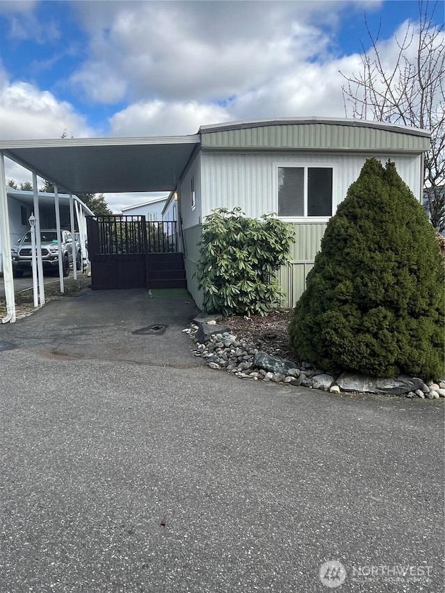 view of side of property featuring a carport and driveway