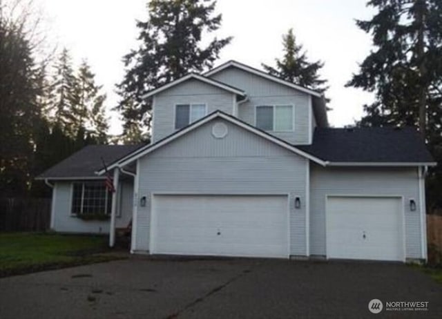 view of front of home with aphalt driveway and an attached garage