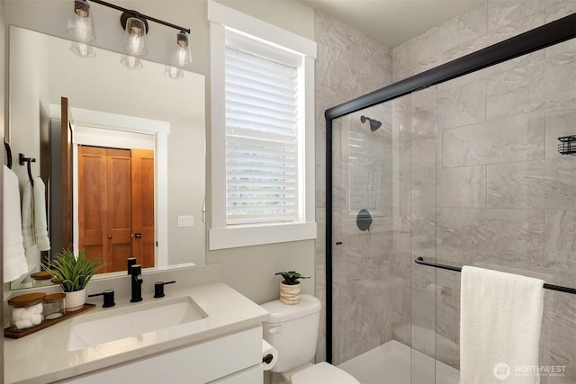 full bathroom featuring toilet, a stall shower, and vanity