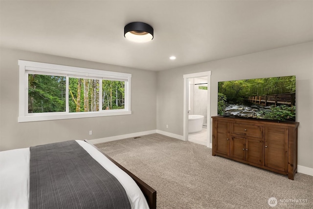 bedroom with recessed lighting, light carpet, ensuite bath, and baseboards