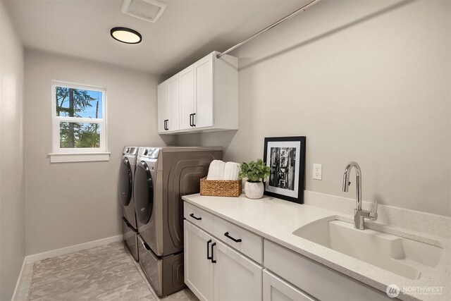 laundry area with cabinet space, baseboards, visible vents, washer and clothes dryer, and a sink