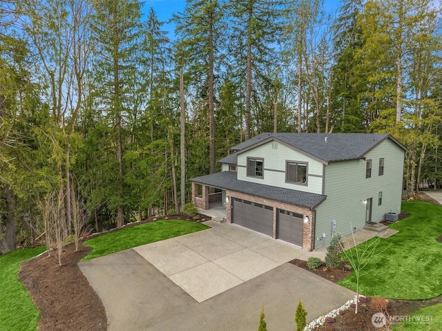 view of front of house with a garage, driveway, a shingled roof, a front yard, and brick siding