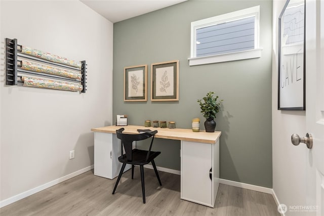 office area with light wood-style floors and baseboards