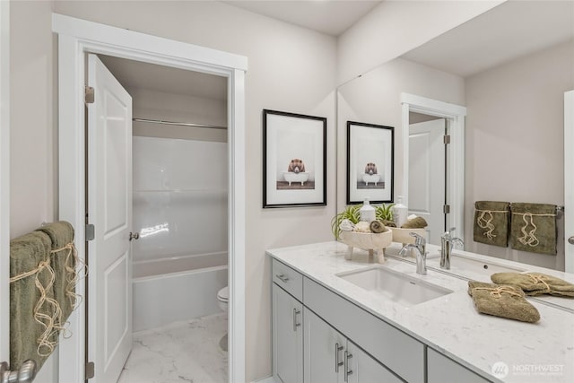 bathroom featuring toilet, marble finish floor, shower / tub combination, and vanity