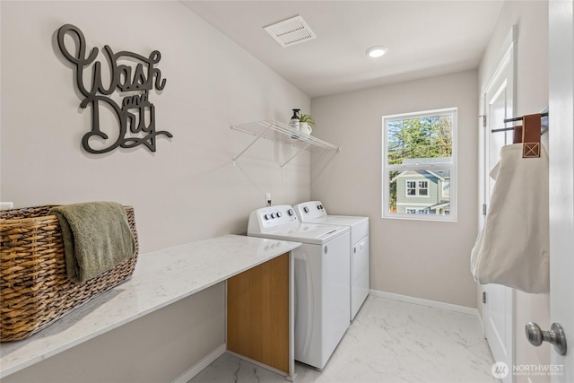 clothes washing area with washer and dryer, marble finish floor, visible vents, and laundry area