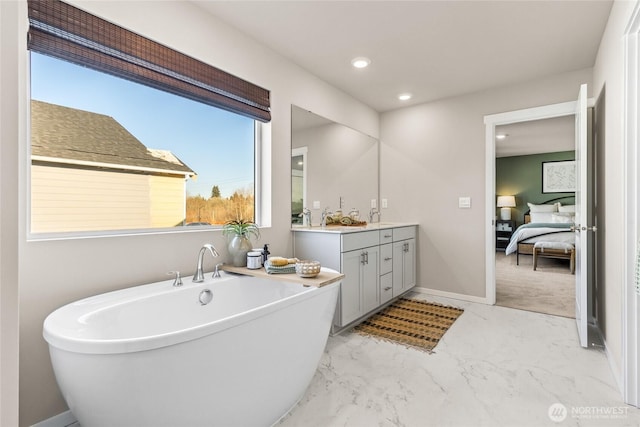 full bath featuring marble finish floor, recessed lighting, a freestanding bath, connected bathroom, and vanity