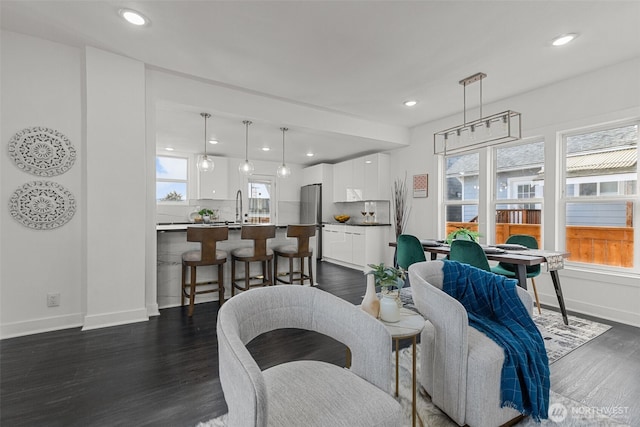 living area with a healthy amount of sunlight, dark wood-style flooring, and recessed lighting