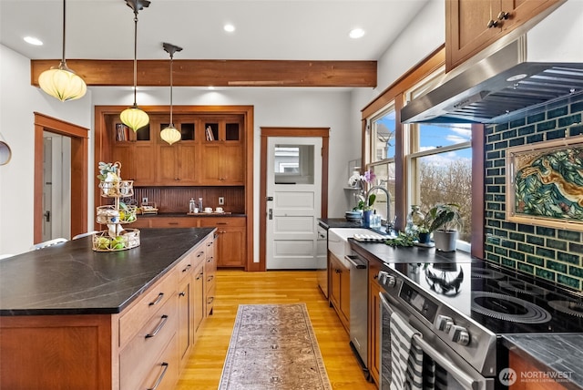 kitchen featuring under cabinet range hood, electric range, tasteful backsplash, and a sink