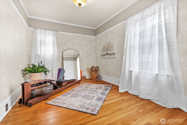 sitting room with ornamental molding and wood finished floors