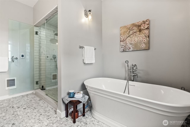 full bath featuring a stall shower, visible vents, a freestanding tub, and tile patterned floors