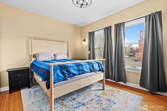 bedroom with baseboards and wood finished floors