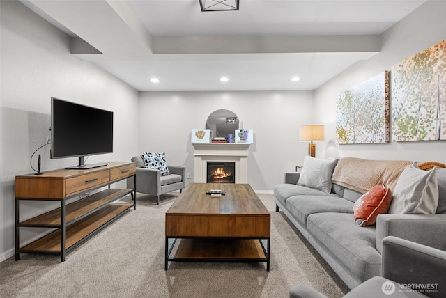 living room with recessed lighting, a warm lit fireplace, carpet flooring, and baseboards