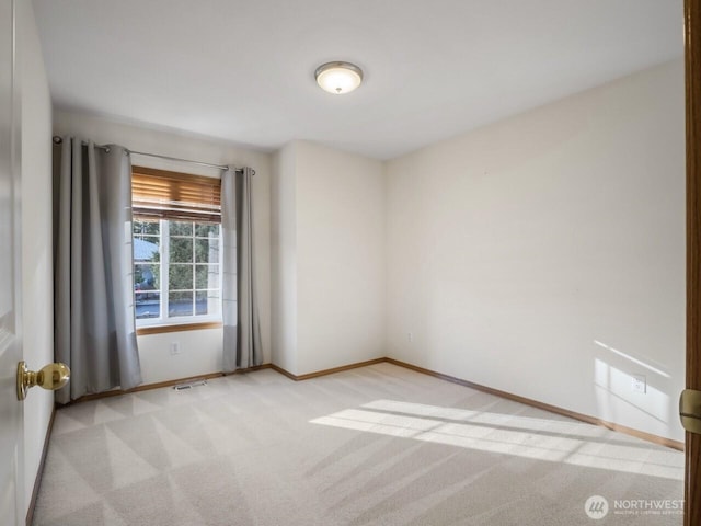 carpeted empty room with visible vents and baseboards