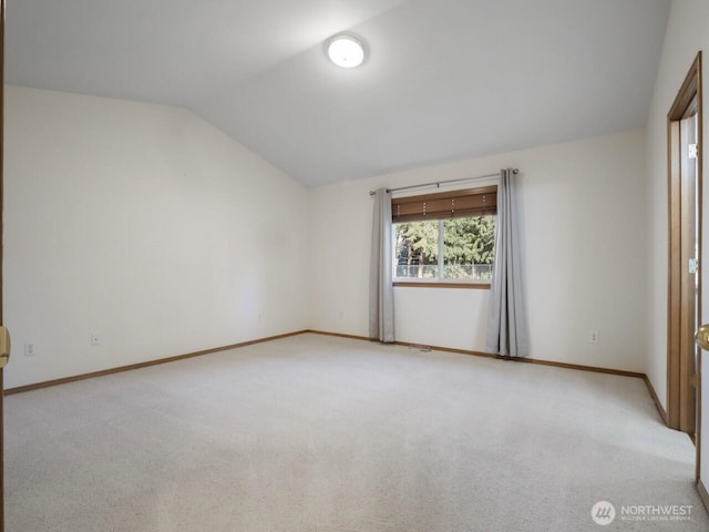 unfurnished room with baseboards, lofted ceiling, and light colored carpet