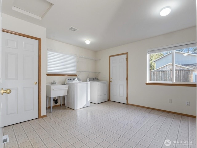 washroom featuring baseboards, attic access, laundry area, independent washer and dryer, and a sink