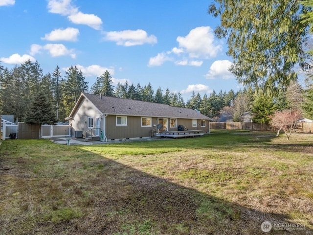 rear view of house with a yard, a fenced backyard, central AC, and crawl space