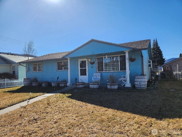 view of front of property featuring a front lawn and fence