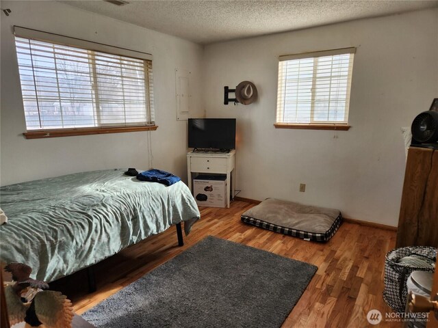 bedroom featuring wood finished floors and a textured ceiling