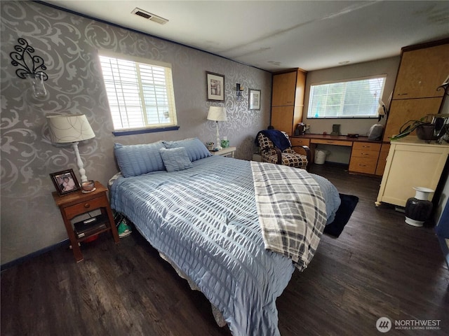 bedroom featuring visible vents, multiple windows, and dark wood-style flooring