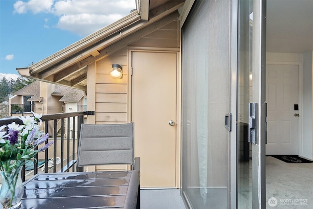 view of exterior entry with a balcony