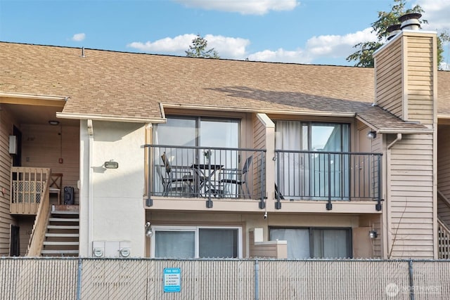 view of building exterior featuring stairway and fence private yard