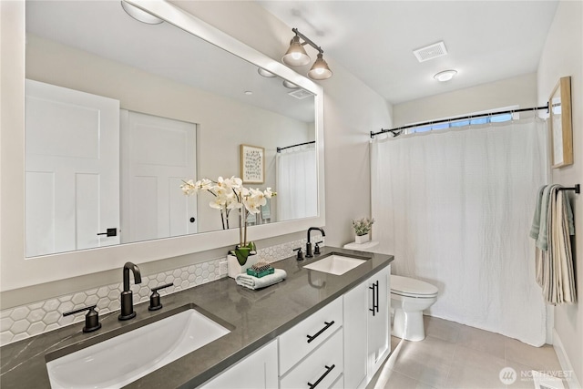 full bath featuring tile patterned flooring, a sink, toilet, and double vanity