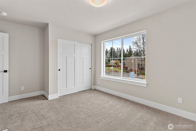 unfurnished bedroom featuring a closet, carpet flooring, and baseboards